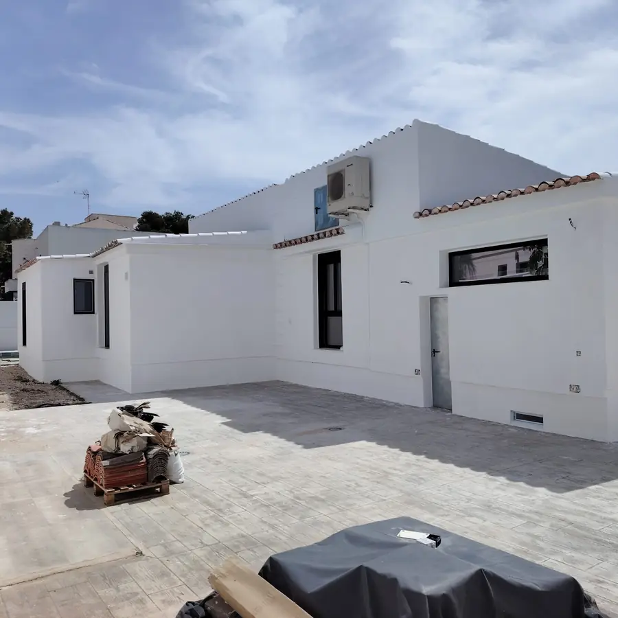 Lateral de una fachada reformada y pintada en blanco